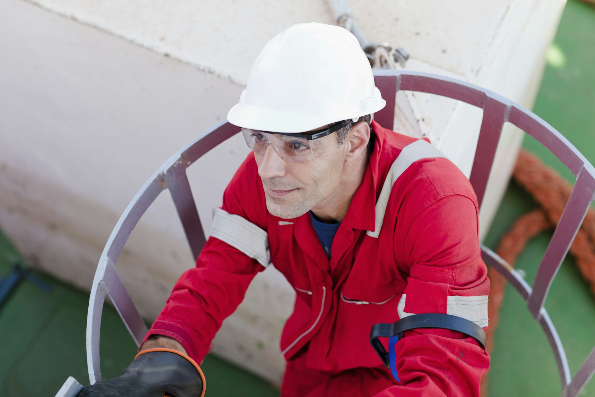 Worker in red overalls climbing a ladder